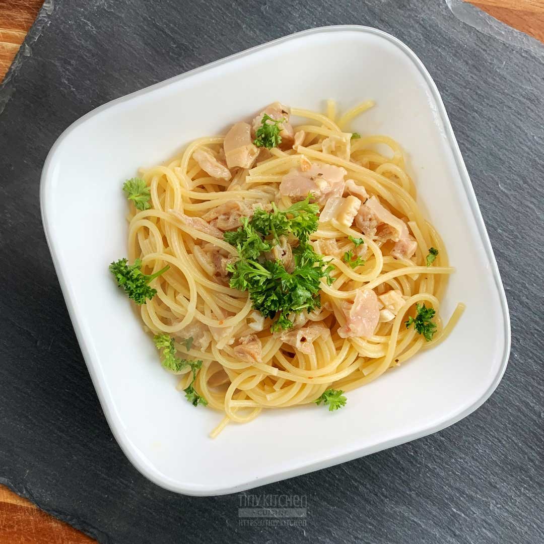 Bowl of spaghetti pasta and clams in a white wine garlic sauce topped with fresh parsley.
